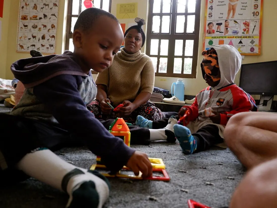 Kinder spielen mit Bauklötzen auf dem Boden