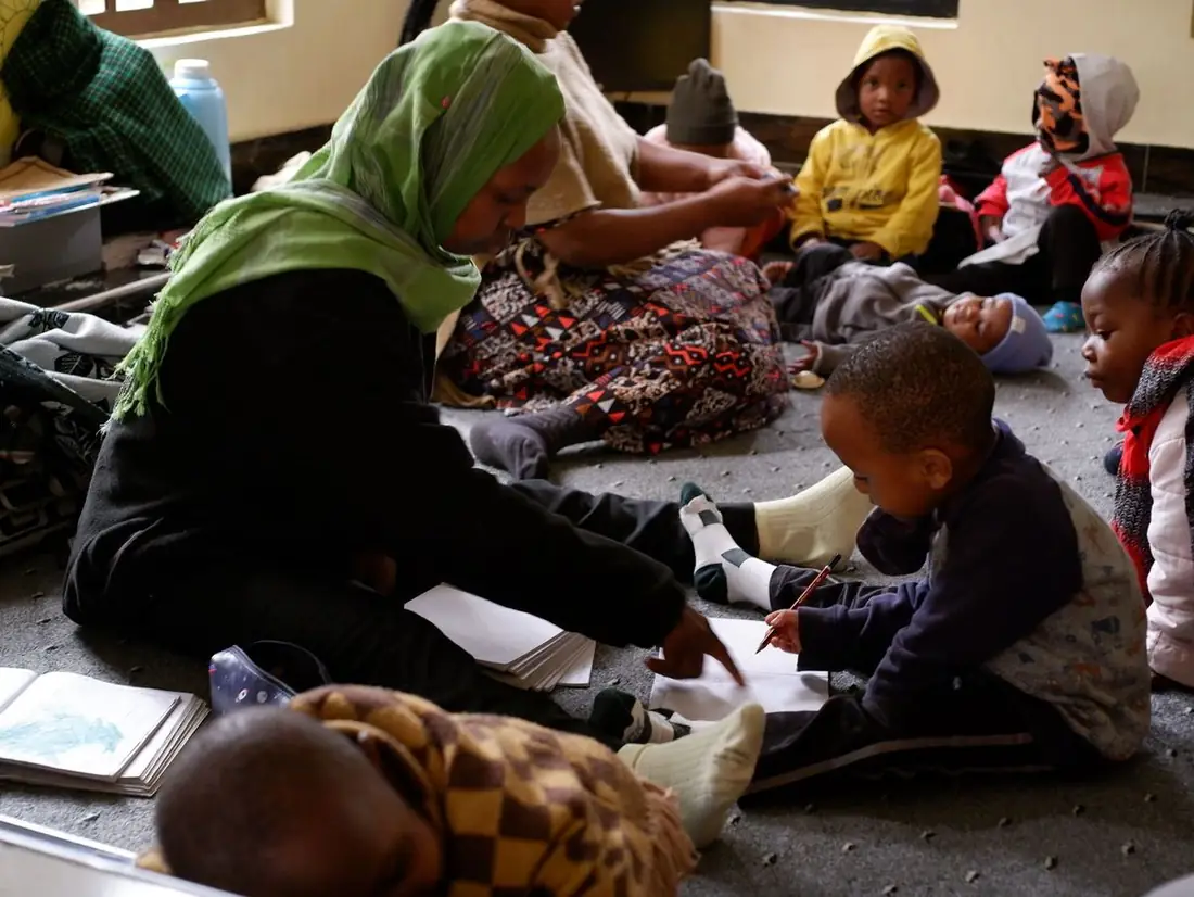 Erzieherin liest mit Kindern in der Daycare