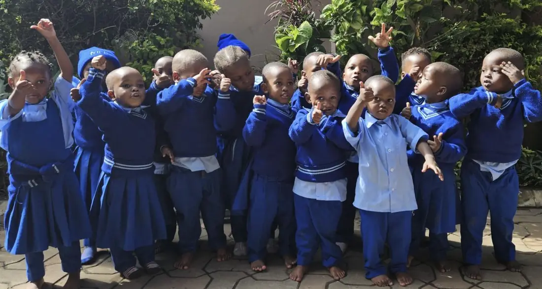 Kinder der Daycare in neuen blauen Schuluniformen